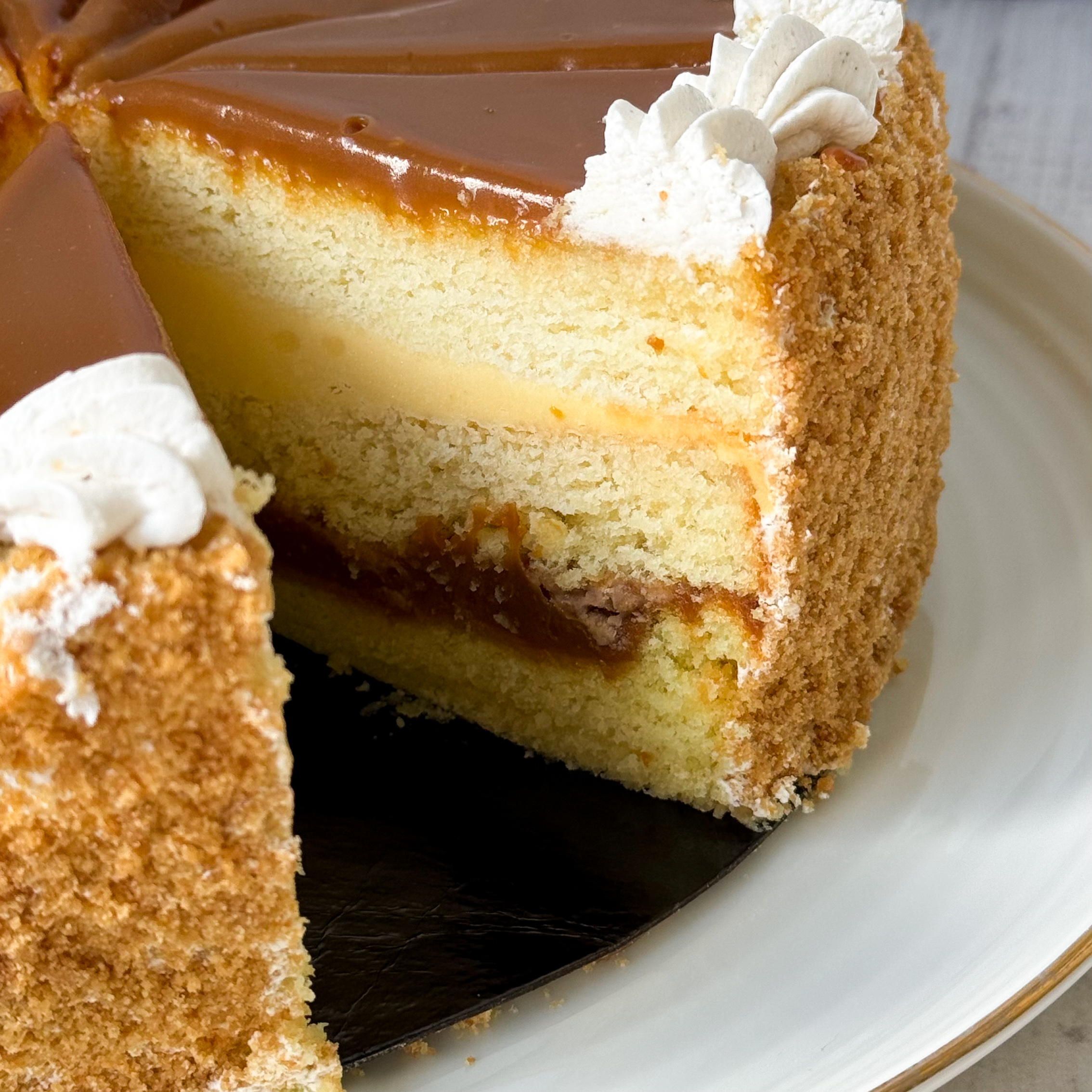 Бисквитный ванильный торт со слоем соленой хрустящей карамели и сливочного крема с молотыми стручками бурбонской ванили, покрыт толстым слоем карамели. изображение 7