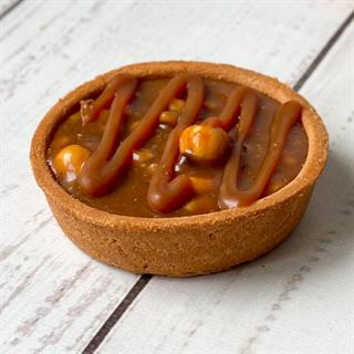 Корзиночка из песочного теста, наполненная арахисом, грецкими орехами и фундуком, украшена карамелью.