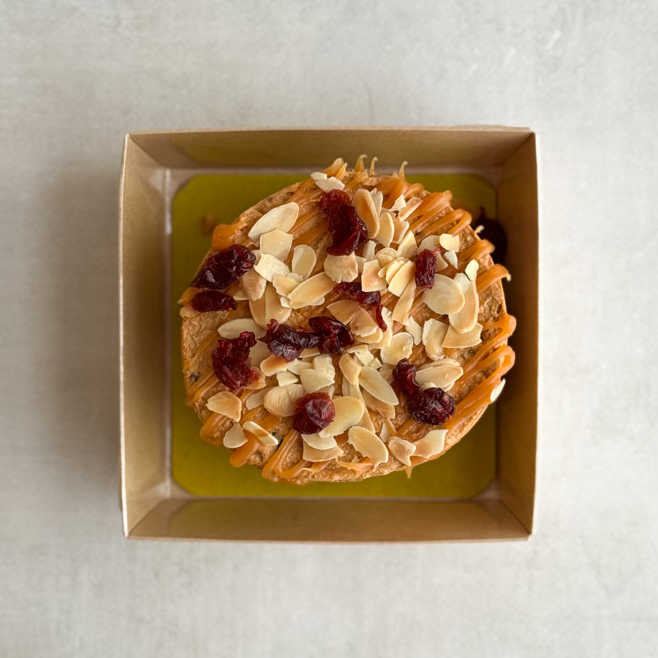  Бенто-торт Руслан в индивид.упаковке. Сочный песочно-карамельный торт с сушеной клюквой и кусочками печенья. Сверху торт украшен волнами мягкой карамели, лепестками миндаля и клюквой.  изображение 3