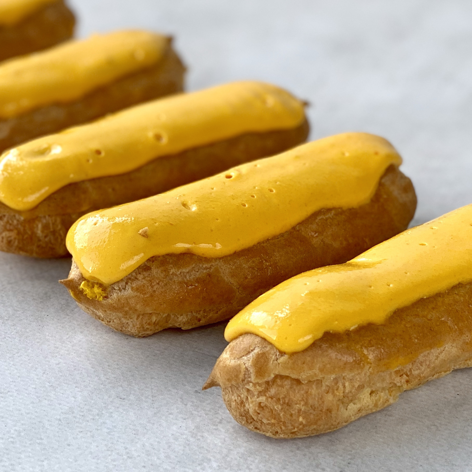 Эклер с начинкой из пюре маракуйи, манго и кремом из взбитых сливок, покрытый помадкой с тропическим вкусом изображение 2