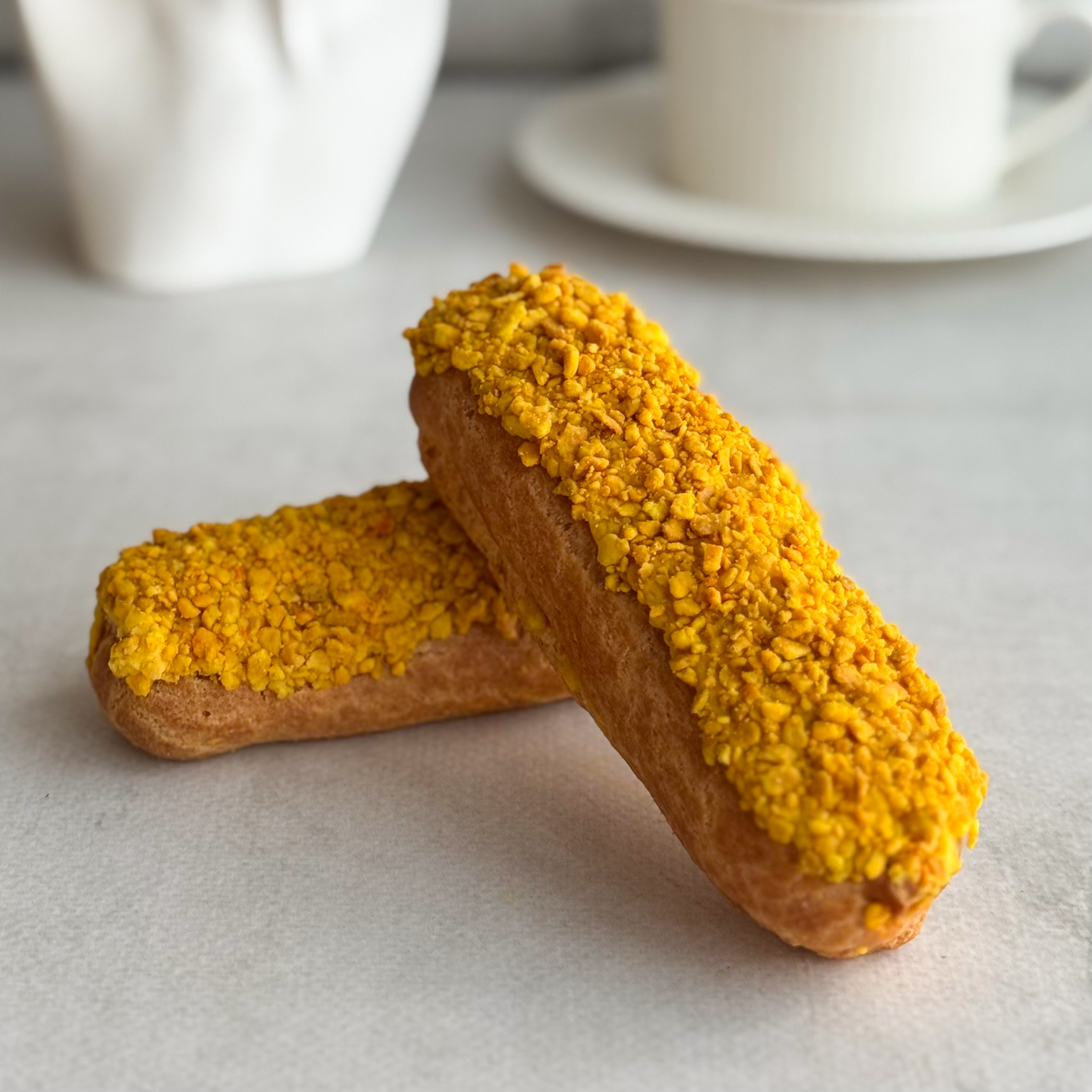 Эклер с начинкой из пюре маракуйи, манго и кремом из взбитых сливок, покрытый помадкой и посыпкой с тропическим вкусом изображение 7