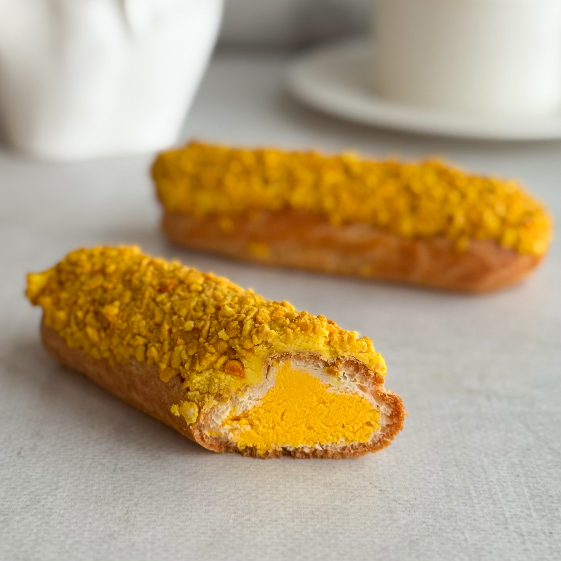 Эклер с начинкой из пюре маракуйи, манго и кремом из взбитых сливок, покрытый помадкой и посыпкой с тропическим вкусом изображение 8