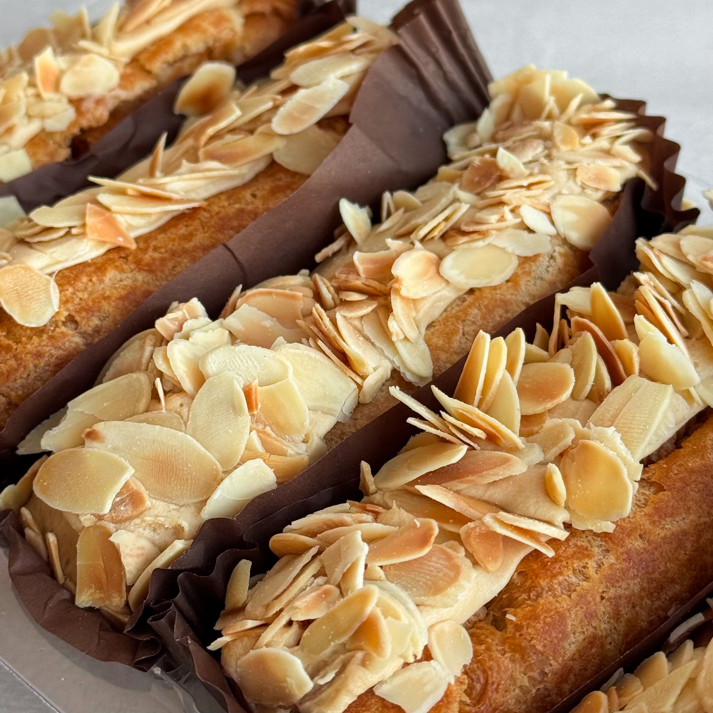 Карамельный эклер с кремом из взбитых сливок с карамелью, украшенный лепестками миндаля изображение 2