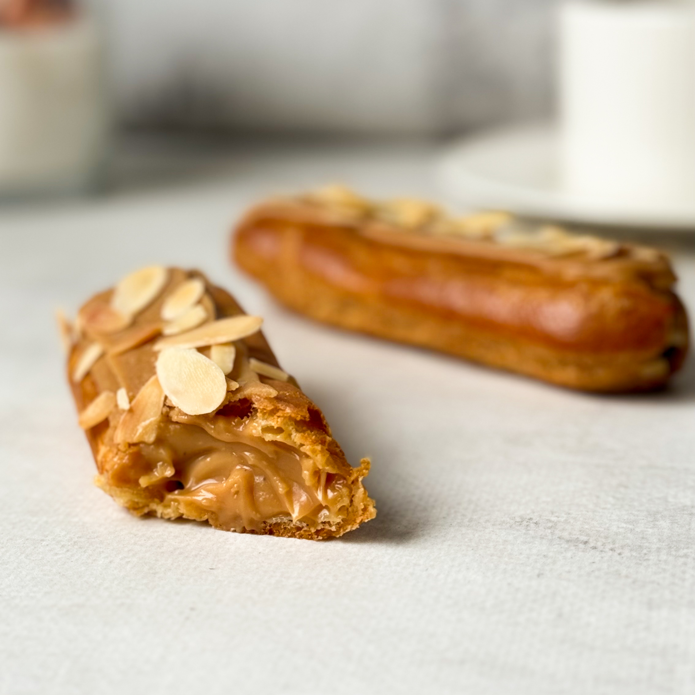 Карамельный эклер с кремом из взбитых сливок с карамелью, украшенный лепестками миндаля изображение 5