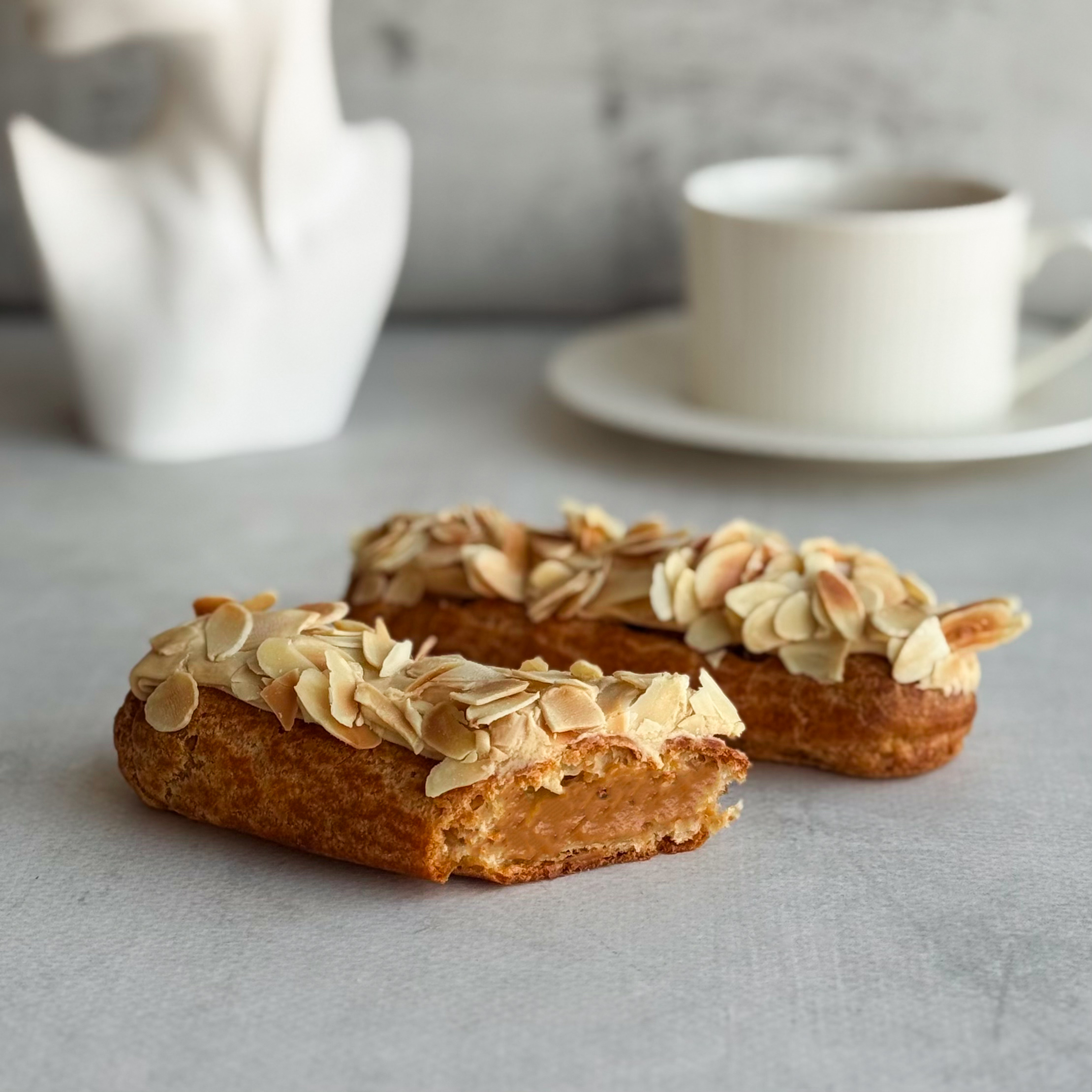 Карамельный эклер с кремом из взбитых сливок с карамелью, украшенный лепестками миндаля изображение 6