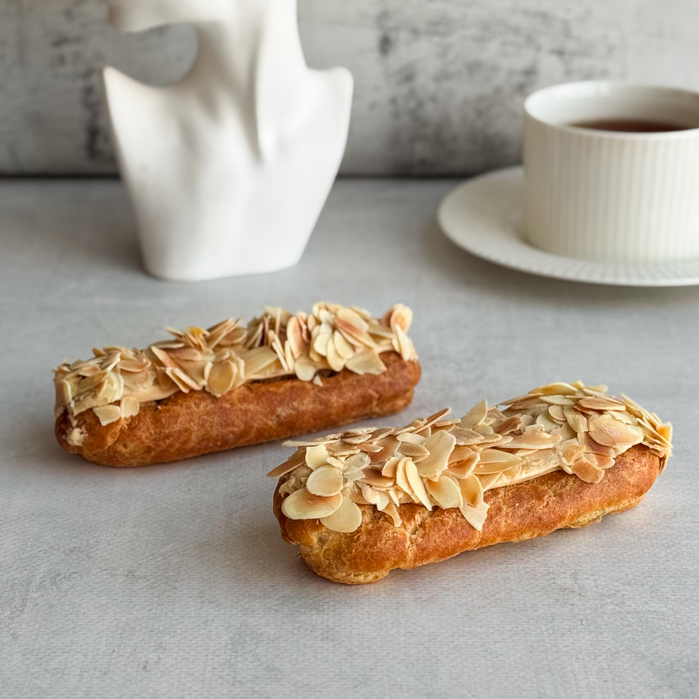 Карамельный эклер с кремом из взбитых сливок с карамелью, украшенный лепестками миндаля изображение 8