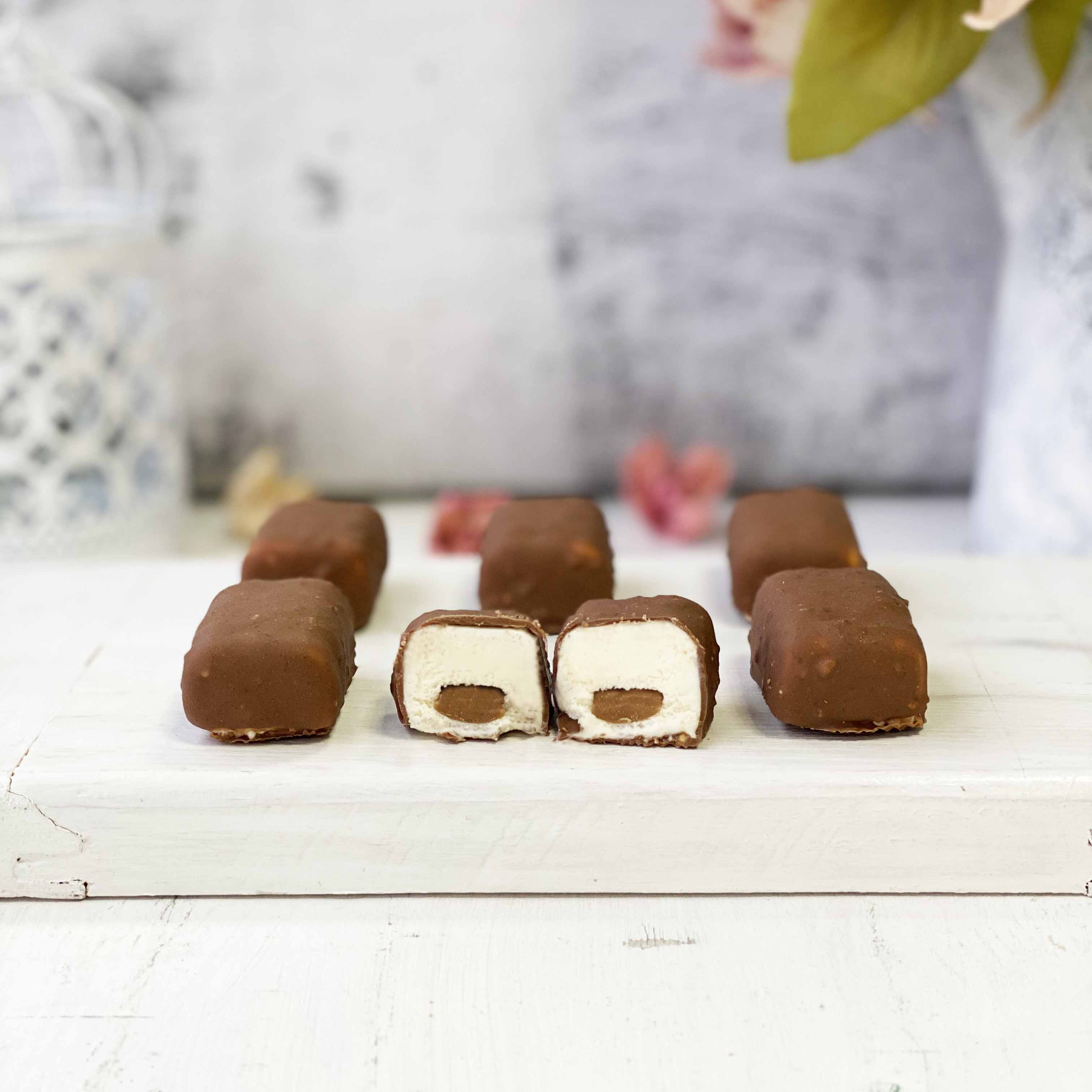 Шоколадные конфеты из ванильного мороженого со вкусом лесного ореха с добавлением сахарного миндаля и фундука, покрытые молочным шоколадом. изображение 1