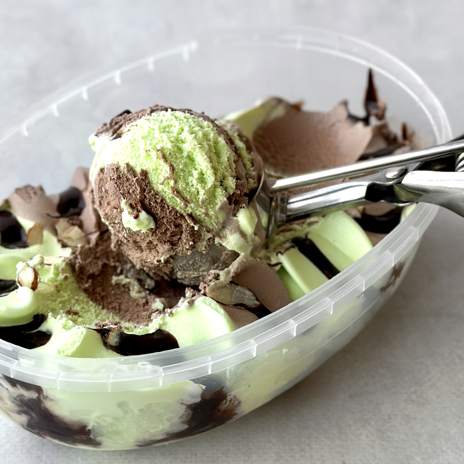 Мороженое в ванне пломбир шоколадно-фисташковый 12% с шоколадным топпингом и лепестками миндаля изображение 2