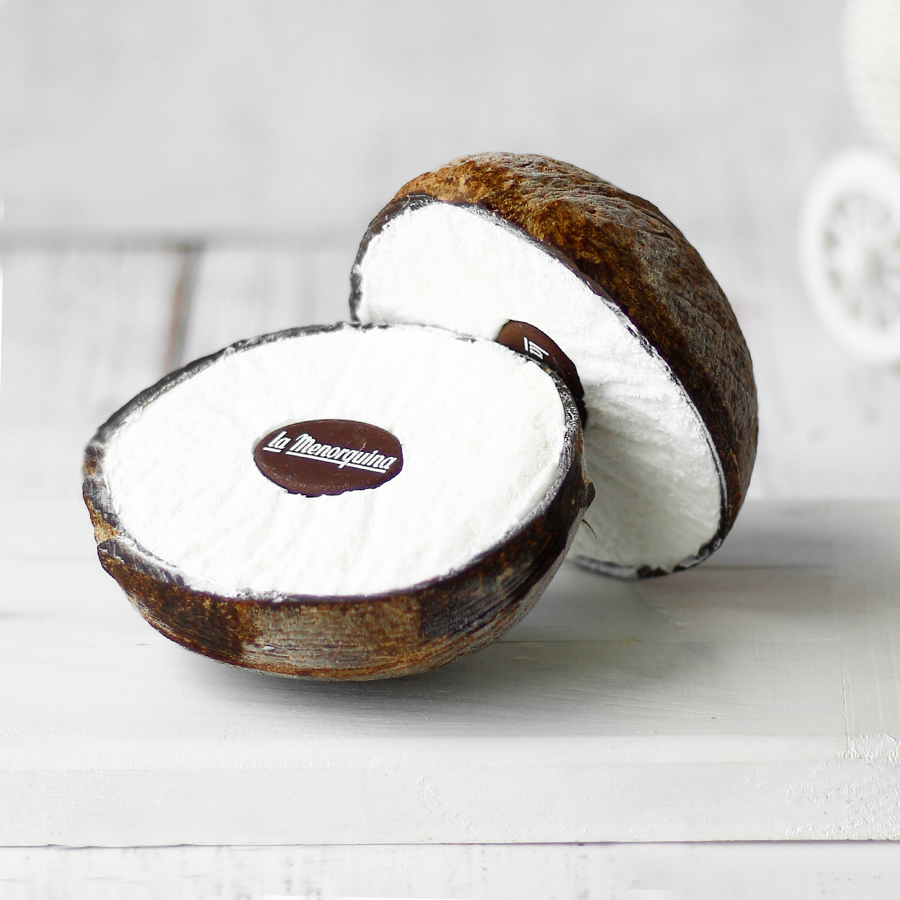 Кокосовый замороженный десерт в оболочке натурального кокосового ореха и с шоколадной медалькой и кокосовой стружкой. изображение 1