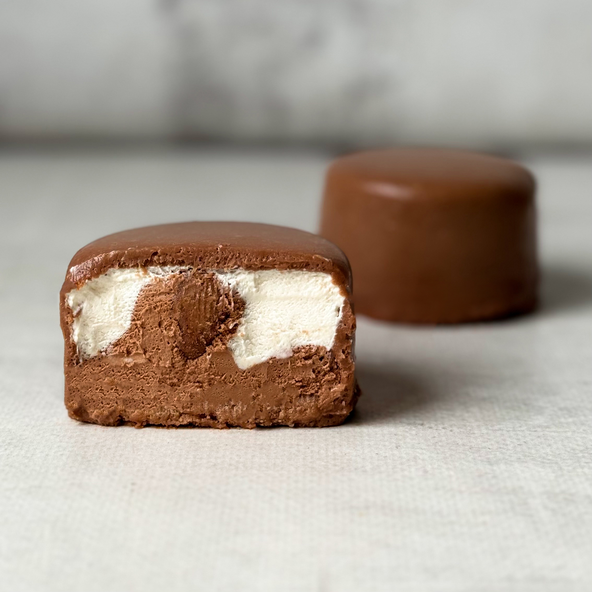 Два слоя из белого и молочного шоколада с хрустящей сердцевиной из фундучного пралине, покрыто молочным шоколадом. изображение 1