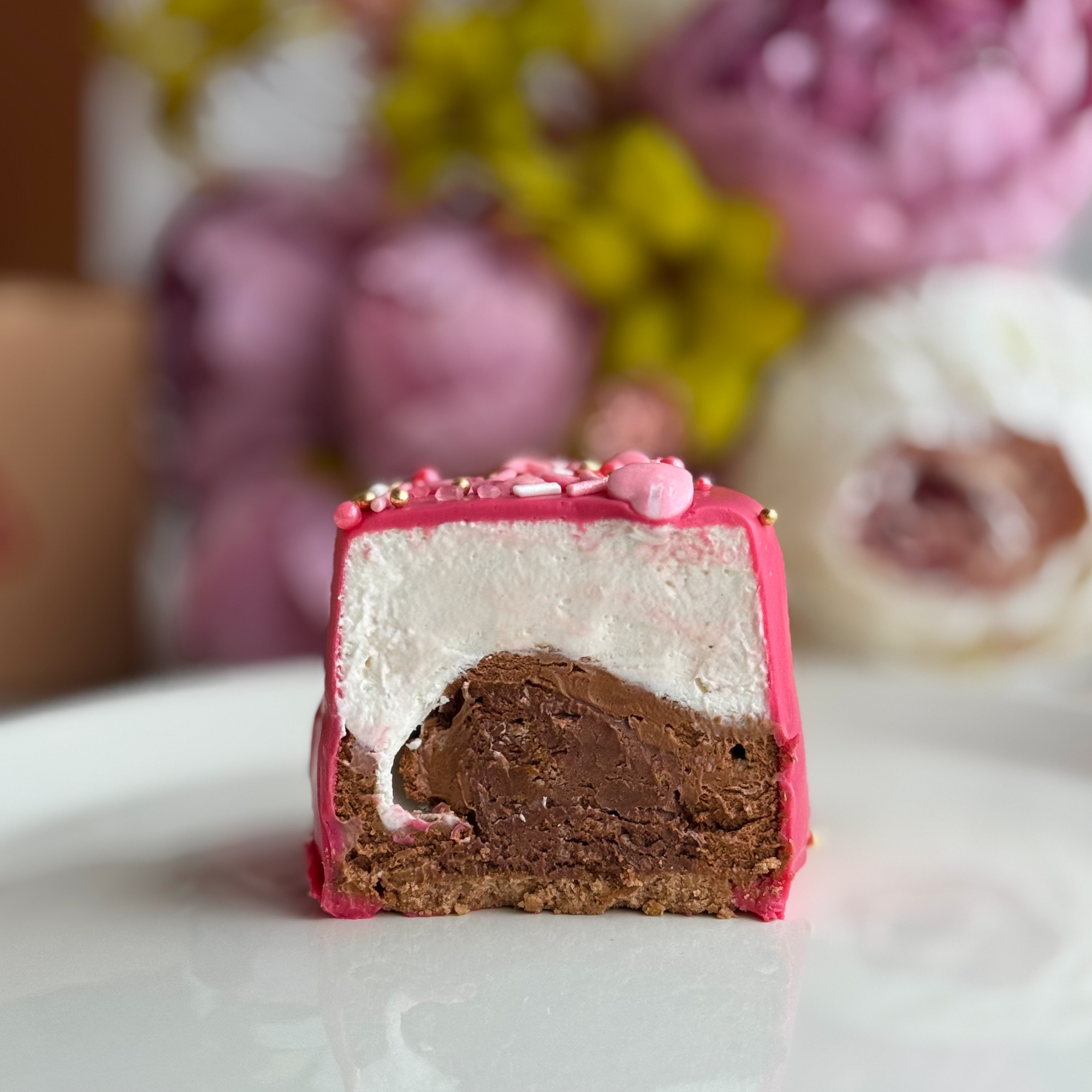 Пирожное Шоколадная бомба (Сердца) Два слоя из белого и молочного шоколада с хрустящей сердцевиной из фундучного пралине в тематическом лимитированном дизайне. изображение 1