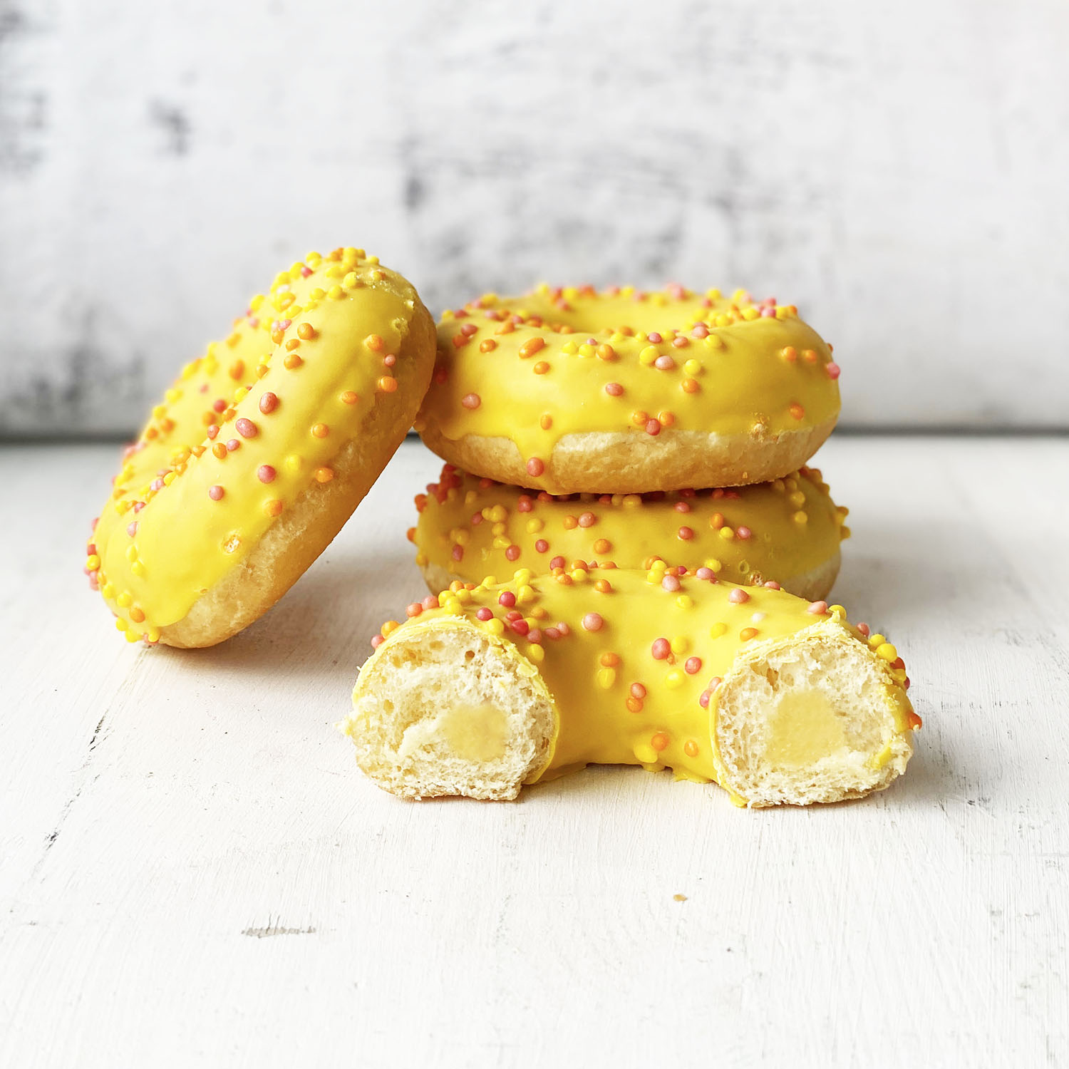 Пончик с желтой глазурью, цветной посыпкой и манговой начинкой изображение 1
