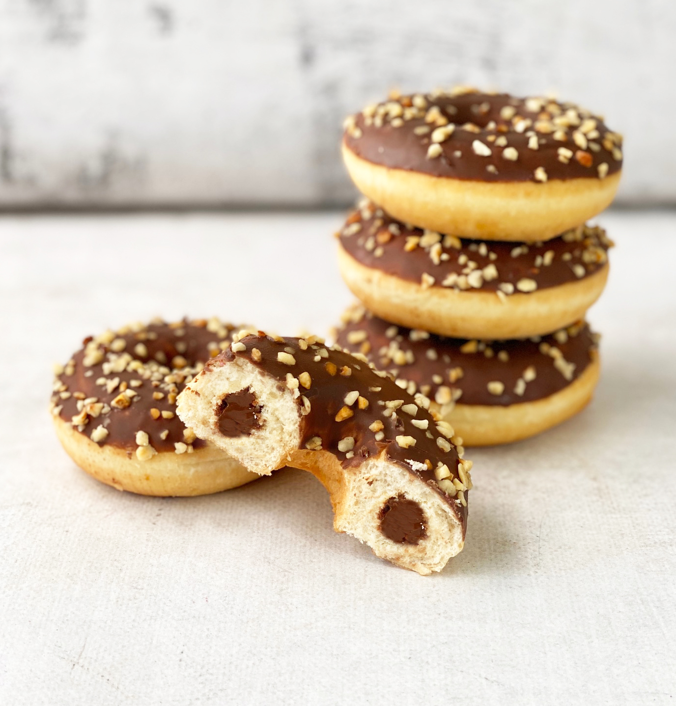 Пончик-донатс с шоколадно-ореховой начинкой, шоколадной кондитерской глазурью с дробленым фундуком изображение 1
