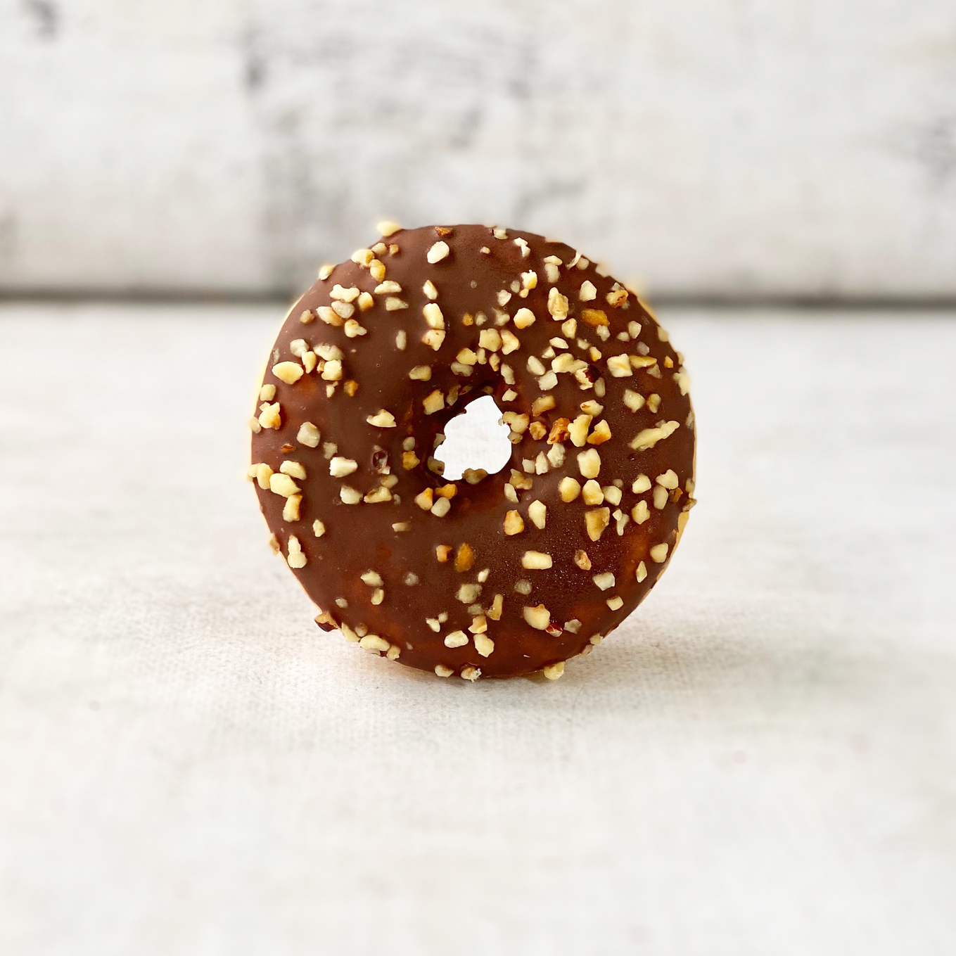 Пончик-донатс с шоколадно-ореховой начинкой, шоколадной кондитерской глазурью с дробленым фундуком изображение 5