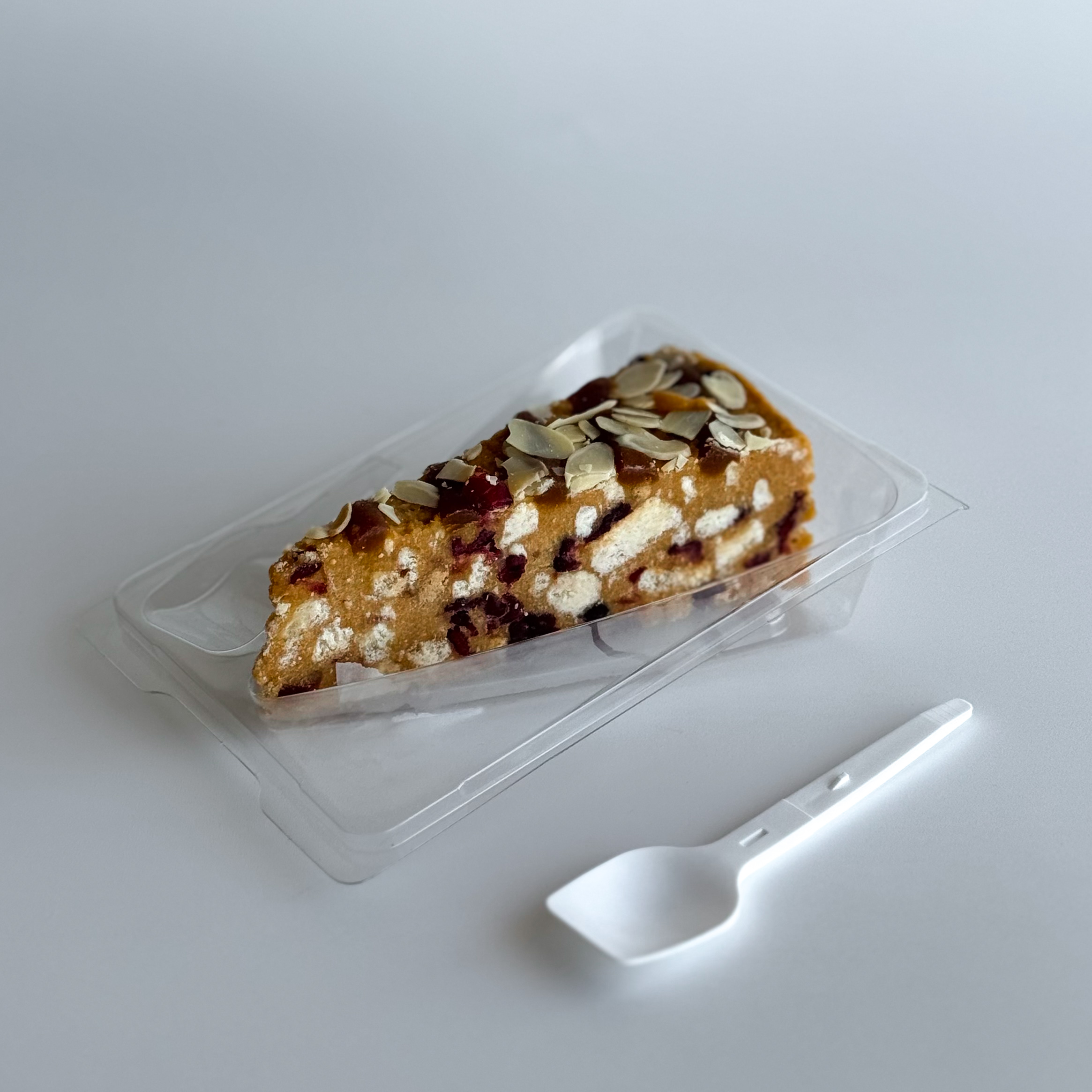 Сочный песочно-карамельный торт с сушеной клюквой и кусочками печенья. Сверху торт украшен волнами мягкой карамели, лепестками миндаля и клюквой.  изображение 1