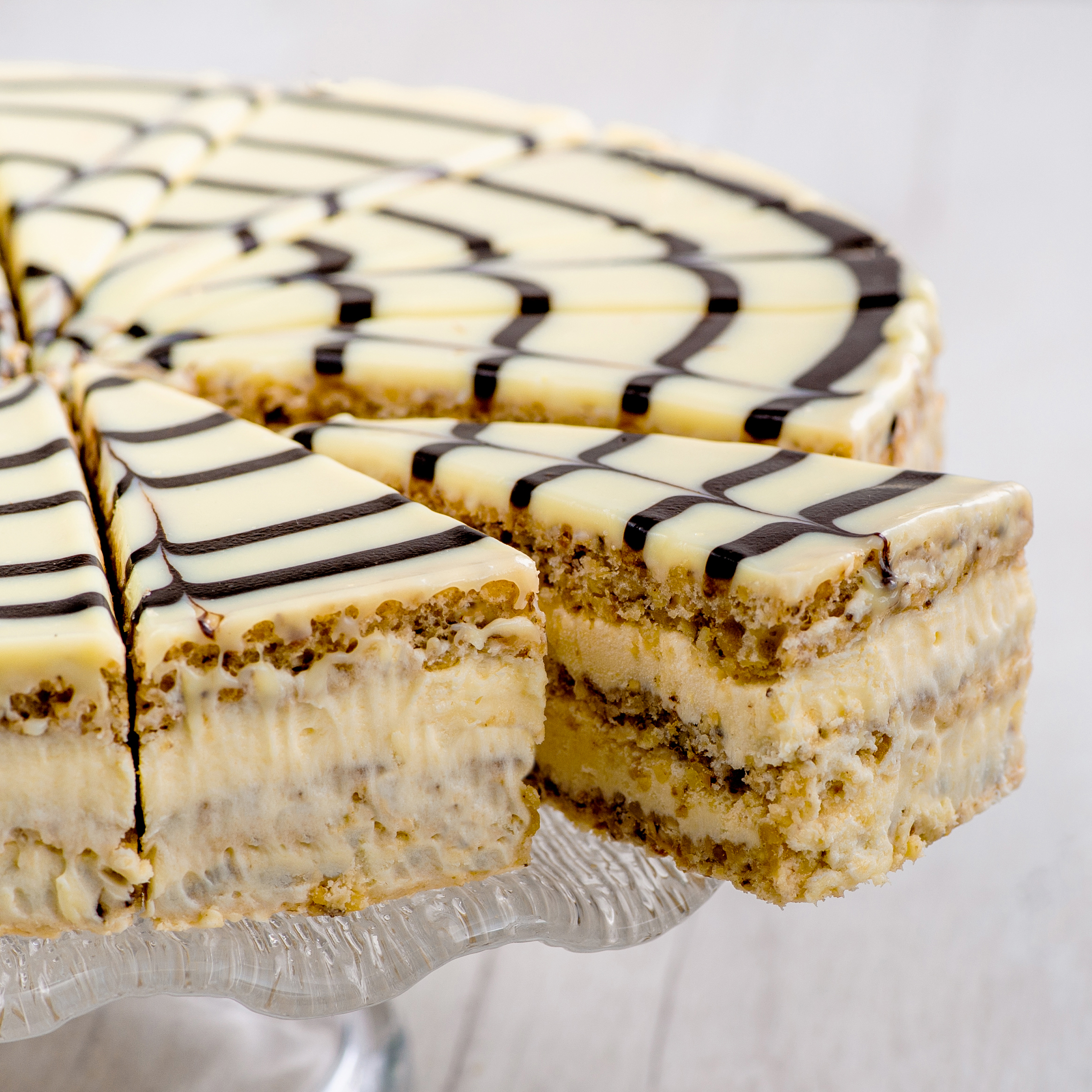 Изысканный классический торт из воздушного ванильно-орехового бисквита, щедро дополненного нежным ванильно-сливочным кремом и посыпанного дробленным орехом. Сверху украшен сахарной помадкой и классическим мраморным рисунком. изображение 2