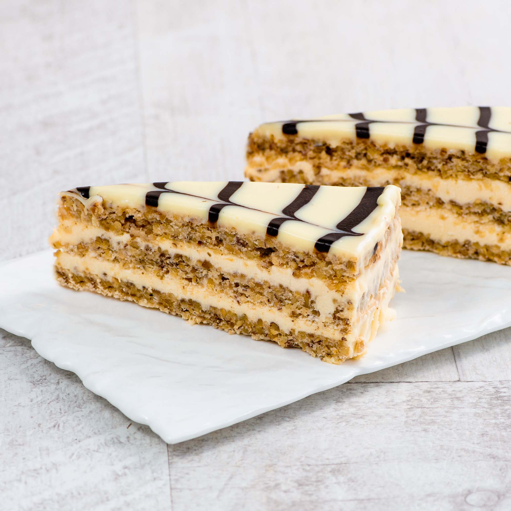 Изысканный классический торт из воздушного ванильно-орехового бисквита, щедро дополненного нежным ванильно-сливочным кремом и посыпанного дробленным орехом. Сверху украшен сахарной помадкой и классическим мраморным рисунком. изображение 3