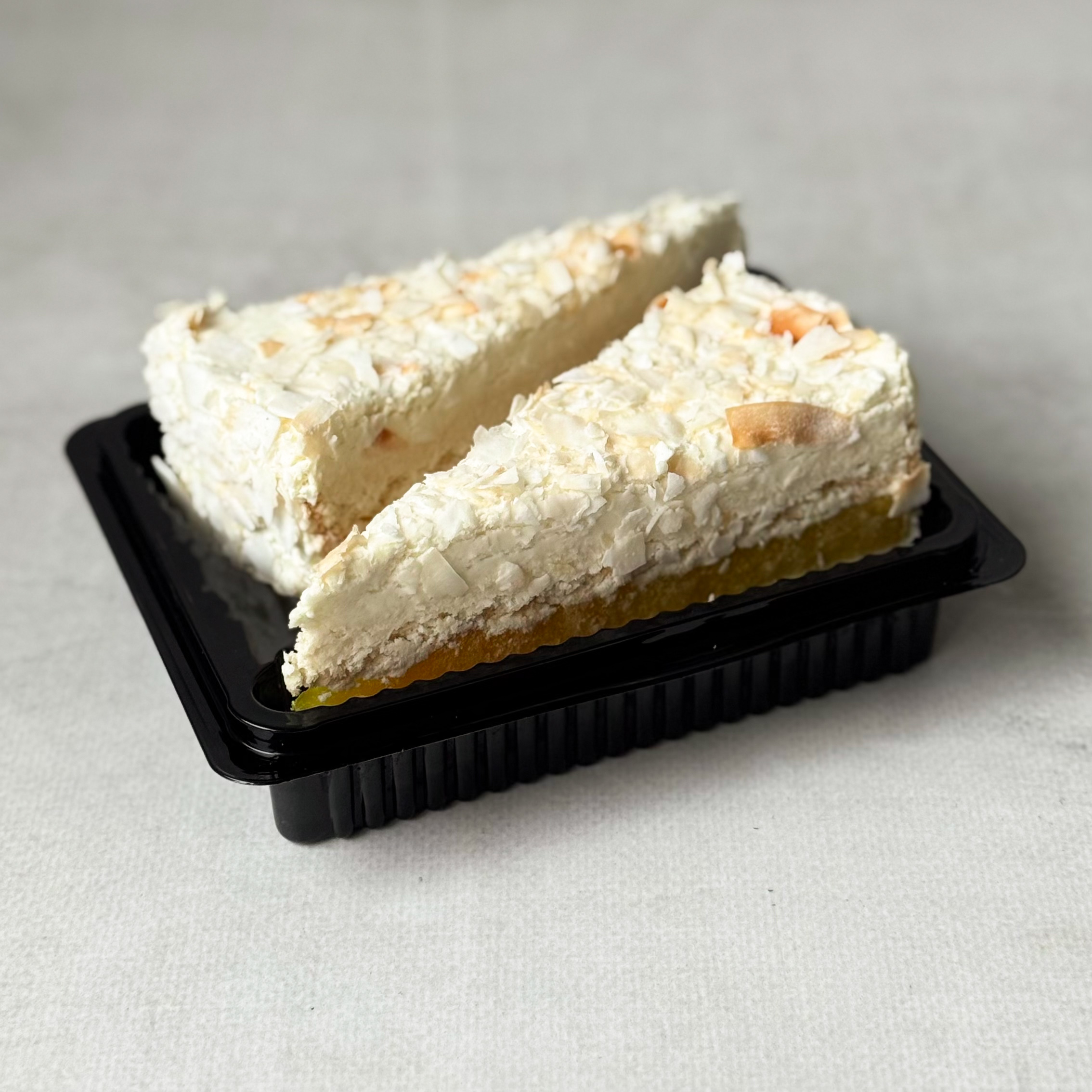 Изысканный торт из слоев кокосового бисквита, крема на основе белого шоколада, взбитых сливок и сочного слоя ананасового конфитюра с кусочками ананаса. Сверху торт украшен обжаренным кокосовым кранчем. изображение 1