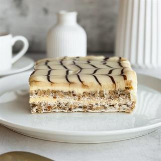  Бенто-торт Эстерхази в индивид.упаковке. Изысканный классический торт из воздушного ванильно-орехового бисквита, щедро дополненного нежным ванильно-сливочным кремом и посыпанного дробленным орехом. Сверху украшен сахарной помадкой и классическим мраморным рисунком.