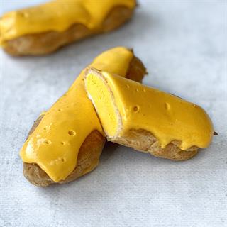 Эклер с начинкой из пюре маракуйи, манго и кремом из взбитых сливок, покрытый помадкой с тропическим вкусом