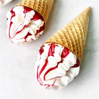 Мороженое сливочное с ароматом ванили, декорированное наполнителем малина-гранат в сахарном вафельном рожке с шоколадной глазурью 