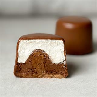 Два слоя из белого и темного шоколада с хрустящей сердцевиной из фундучного пралине, покрыто молочным шоколадом.